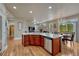 Kitchen island featuring granite countertops, stainless steel dishwasher, wood cabinets, and hardwood floors at 3434 Fantasy Pl, Castle Rock, CO 80109
