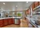 Spacious kitchen features hardwood floors, wood cabinets, stainless steel appliances, granite countertops, and an adjacent eating area at 3434 Fantasy Pl, Castle Rock, CO 80109