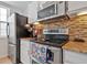 Efficient kitchen featuring stainless steel appliances, granite countertops, and stylish tile backsplash at 5765 W Atlantic Pl # 104, Lakewood, CO 80227