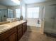 Bright bathroom with double sink vanity, soaking tub, and glass-enclosed shower at 5626 S Biloxi Way, Aurora, CO 80016