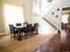 Bright dining area with a wooden table, seating for six, a staircase, and large sunlit windows at 5626 S Biloxi Way, Aurora, CO 80016