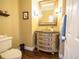 Elegant powder room with a decorative vanity, framed mirror, and hardwood floors at 5626 S Biloxi Way, Aurora, CO 80016