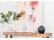 Stylish decor featuring a colorful abstract painting, eucalyptus, and decorative objects atop a wooden console table at 1061 Adams St, Denver, CO 80206