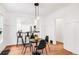 Cozy dining area with modern pendant lighting, black chairs, and hardwood floors, seamlessly connected to kitchen at 1061 Adams St, Denver, CO 80206