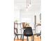 Modern dining area featuring pendant lighting, black chairs, and seamlessly integrated with the well-equipped kitchen at 1061 Adams St, Denver, CO 80206