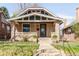 Charming brick home with a well-manicured lawn and welcoming front porch with a swing at 1061 Adams St, Denver, CO 80206