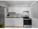 Modern kitchen features white cabinetry, sleek countertops, subway tile backsplash, and stainless steel appliances, well lit by a window at 529 E 14Th Ave # 10, Denver, CO 80203