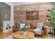 Cozy living room with a brick accent wall, hardwood floors, and stylish decor at 529 E 14Th Ave # 10, Denver, CO 80203