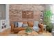 Close-up of a living room showcasing brick wall, hardwood floors, and decorative furnishings at 529 E 14Th Ave # 10, Denver, CO 80203