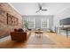 Bright living room featuring hardwood floors, a brick wall, and large windows for plenty of natural light at 529 E 14Th Ave # 10, Denver, CO 80203