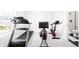 Home gym featuring a treadmill, exercise bike, and mounted TV screen at 8357 W 68Th Ln, Arvada, CO 80004