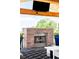 Close-up of a stylish fireplace on an outdoor patio, complete with mounted TV and inviting seating, perfect for gatherings at 8357 W 68Th Ln, Arvada, CO 80004