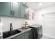Well-organized laundry room with modern washer/dryer, sink, and ample storage at 8357 W 68Th Ln, Arvada, CO 80004