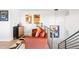 Stylish living room featuring comfortable orange furniture, unique artwork, and modern lighting, creating a warm and inviting atmosphere at 8357 W 68Th Ln, Arvada, CO 80004