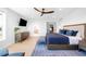 Bright main bedroom features blue accents, a large bed, and attached bath at 8357 W 68Th Ln, Arvada, CO 80004