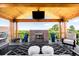 Cozy outdoor area featuring a fireplace, mounted TV, comfortable seating, and a scenic view for relaxation and entertainment at 8357 W 68Th Ln, Arvada, CO 80004