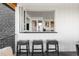 Outdoor bar featuring a pass-through window, seating, and access to indoor living, creating seamless indoor-outdoor experience at 8357 W 68Th Ln, Arvada, CO 80004