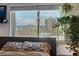 This cozy bedroom features an eye-catching decorative wall hanging and large windows with mountain views at 1233 N Ogden St # 610, Denver, CO 80218