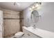 Stylish bathroom featuring a tiled shower, a round mirror, and a modern vanity with white cabinets at 7814 W Ontario Pl, Littleton, CO 80128