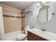 Cozy bathroom with tiled shower/tub, modern fixtures, and a stylish round mirror at 7814 W Ontario Pl, Littleton, CO 80128