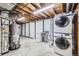 Basement laundry area featuring a stacked washer and dryer, utility sink, and open ceiling at 7814 W Ontario Pl, Littleton, CO 80128