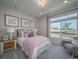 Comfortable bedroom with pink bedding, large windows, and a cozy armchair at 21947 E 51St Dr, Aurora, CO 80019