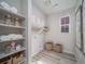 Bright laundry room with storage shelves, wicker baskets, and light wood flooring at 21947 E 51St Dr, Aurora, CO 80019