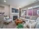 Cozy living room with a fireplace, large windows, and comfortable seating area at 21947 E 51St Dr, Aurora, CO 80019