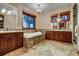 Elegant bathroom with a large soaking tub, double vanities, and stone tile at 457 Timber Trail Rd, Breckenridge, CO 80424