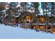 Stunning mountain home with stone and wood exterior, snow covered roof and large windows at 457 Timber Trail Rd, Breckenridge, CO 80424