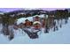 Luxury home nestled in snowy trees with mountain backdrop at 457 Timber Trail Rd, Breckenridge, CO 80424