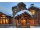 Enticing front entrance to a luxurious home; stone and wood exterior, covered entryway at 457 Timber Trail Rd, Breckenridge, CO 80424
