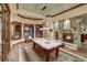 Basement game room with pool table, stone fireplace, and large windows at 457 Timber Trail Rd, Breckenridge, CO 80424