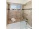 Bathroom featuring tub with shower, neutral tile, and tile accent at 6 White Alder, Littleton, CO 80127
