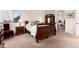 Bedroom with neutral carpet, wood furnishings, and access to ensuite bath at 6 White Alder, Littleton, CO 80127