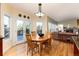 Well-lit dining room with round wood table set, access to outdoor deck, and views of living room at 6 White Alder, Littleton, CO 80127