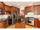 Elegant kitchen with stainless appliances, granite countertops, cherry wood cabinets, central island, and wine fridge at 6 White Alder, Littleton, CO 80127