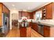 Stylish kitchen featuring hardwood floors, cherry wood cabinets, granite countertops, stainless appliances, and central island at 6 White Alder, Littleton, CO 80127