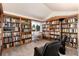 Inviting library with custom wooden bookshelves, seating, and natural light from a window at 6 White Alder, Littleton, CO 80127