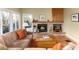 Comfortable living room featuring fireplace with brick surround and ample natural light at 6 White Alder, Littleton, CO 80127