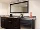 Elegant wet bar features dark cabinetry, granite countertop, a sink, and a beverage refrigerator at 6 White Alder, Littleton, CO 80127