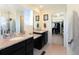 Bathroom with double vanity, granite countertop, and a view into the primary walk-in closet at 1334 Barberry Trl, Elizabeth, CO 80107
