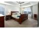Bright primary bedroom featuring tray ceiling, large windows, and a wood-frame bed at 1334 Barberry Trl, Elizabeth, CO 80107