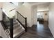 Bright entryway features wood floors, carpeted stairs with dark wood railing, and a view into the living room at 1334 Barberry Trl, Elizabeth, CO 80107