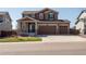 Inviting two-story home boasts a three car garage, manicured lawn, and charming front porch at 1334 Barberry Trl, Elizabeth, CO 80107