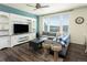 Cozy living room with large windows, wood floors, and a built-in entertainment center at 1334 Barberry Trl, Elizabeth, CO 80107