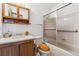 Traditional bathroom featuring a vanity, toilet, and shower-tub combination with a glass sliding door at 1418 5Th St, Fort Lupton, CO 80621