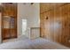 The neutral bedroom features wood paneled walls, plush carpet, and ensuite bath at 3515 S Dawson St, Aurora, CO 80014