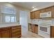Cozy kitchen with oak cabinets and modern white appliances and white countertops at 3515 S Dawson St, Aurora, CO 80014