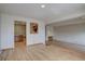 Open-concept living space with hardwood floors, brick accent wall, and pass through to kitchen at 3515 S Dawson St, Aurora, CO 80014